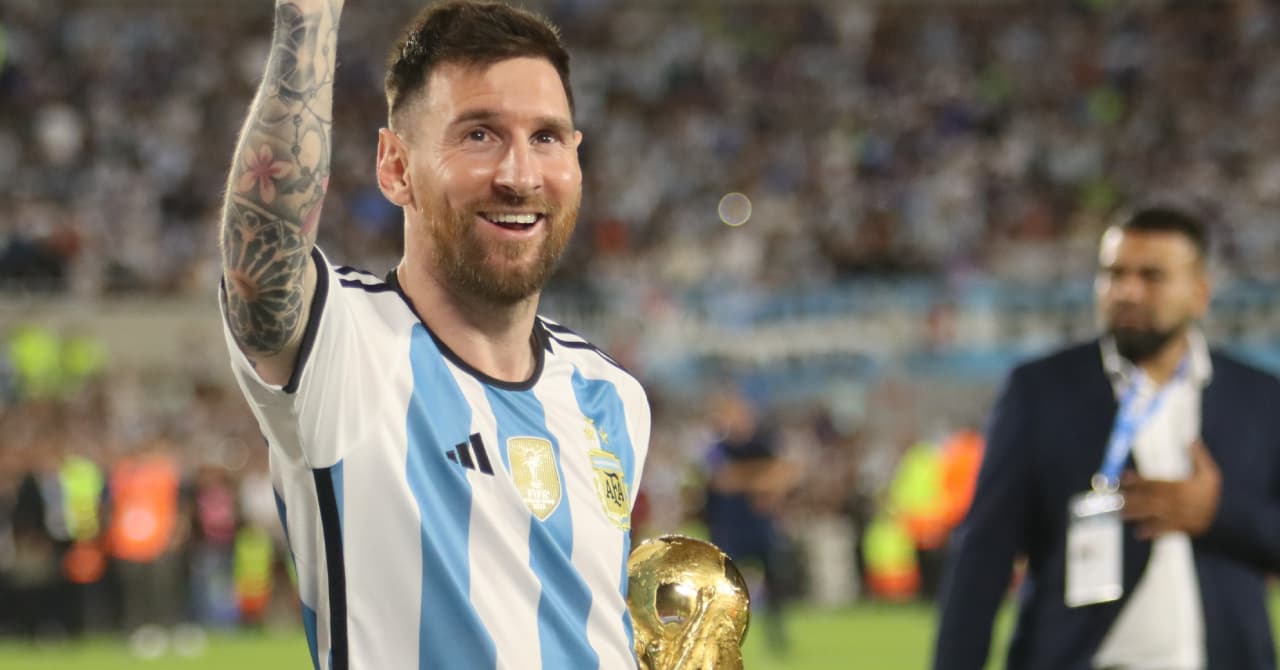 Player celebrating with World Cup trophy on field Player celebrating with World Cup trophy on field