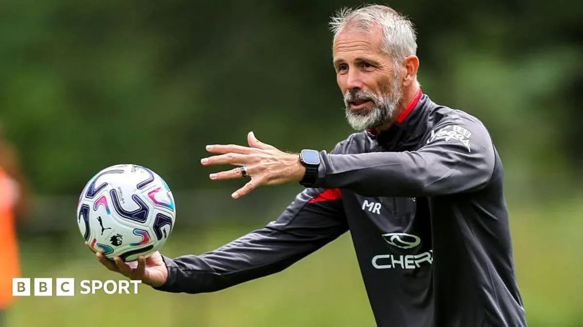 Coach demonstrating techniques while holding a football Coach demonstrating techniques while holding a football