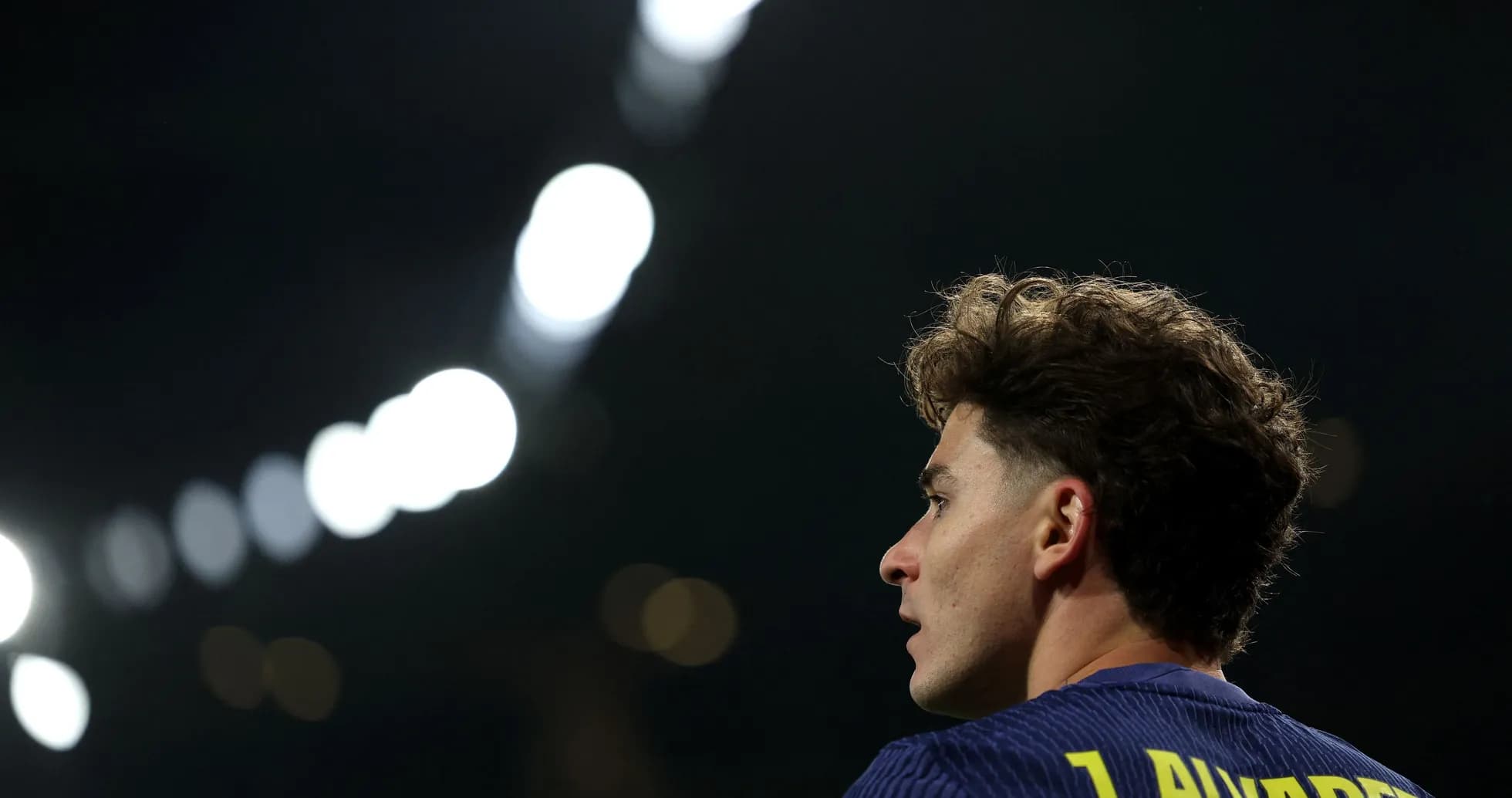 Player looking away during match under stadium lights Player looking away during match under stadium lights