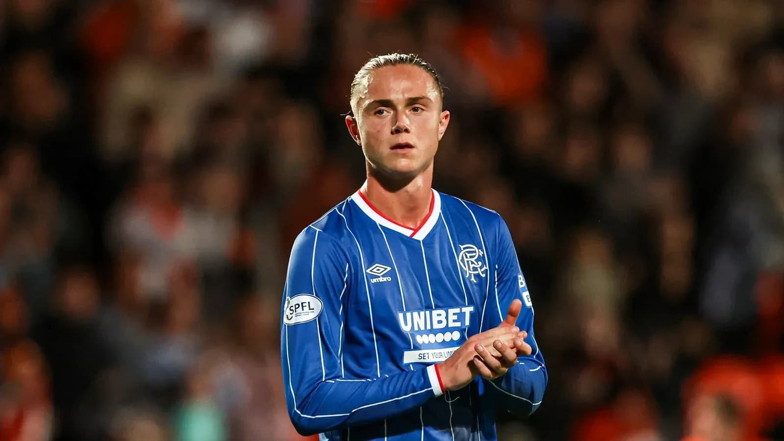 Player in blue kit clapping to fans at stadium Player in blue kit clapping to fans at stadium