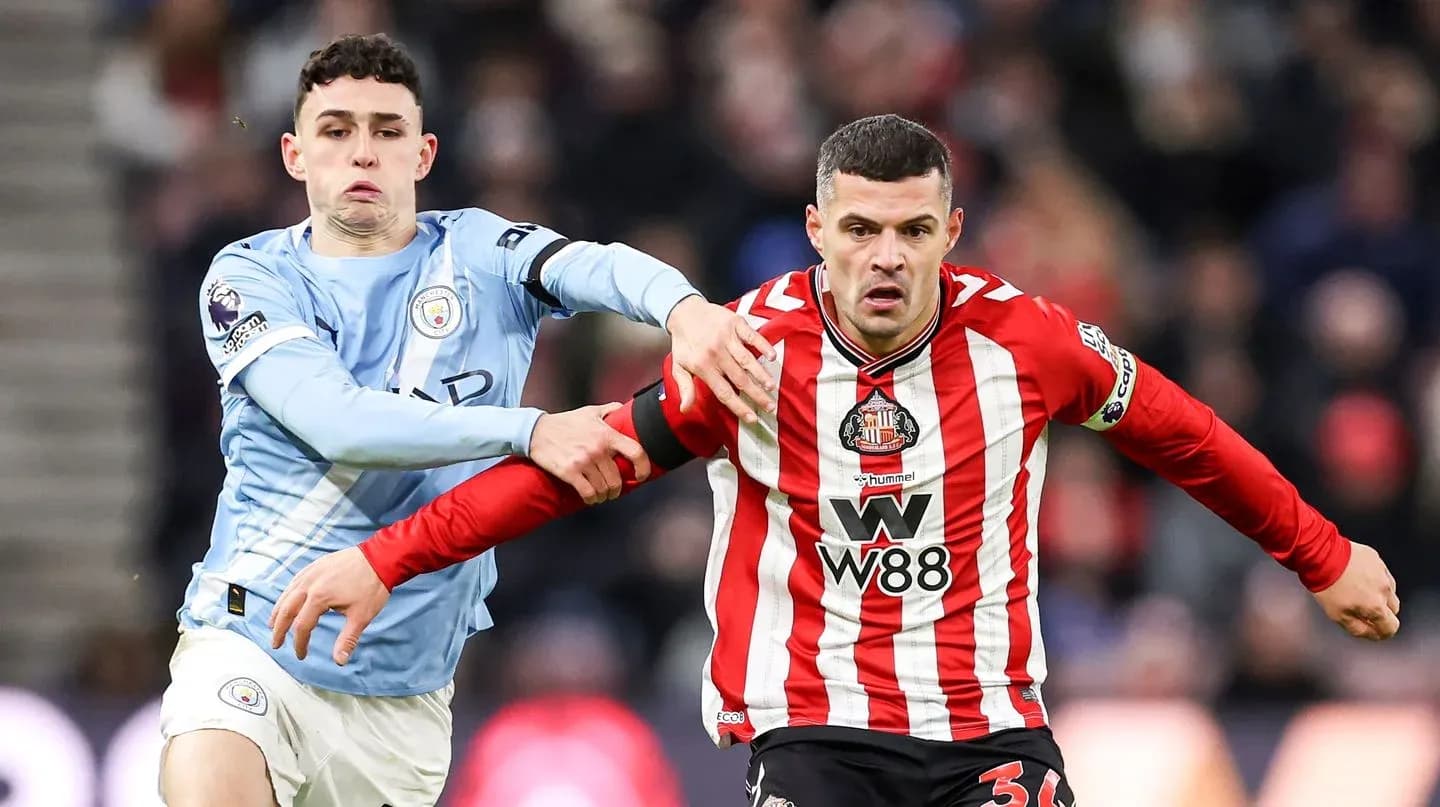 Manchester City player challenging Sunderland opponent Manchester City player challenging Sunderland opponent
