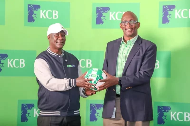 Two individuals holding a soccer ball at KCB event Two individuals holding a soccer ball at KCB event