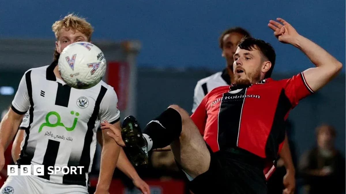 Player kicking ball during football match action Player kicking ball during football match action
