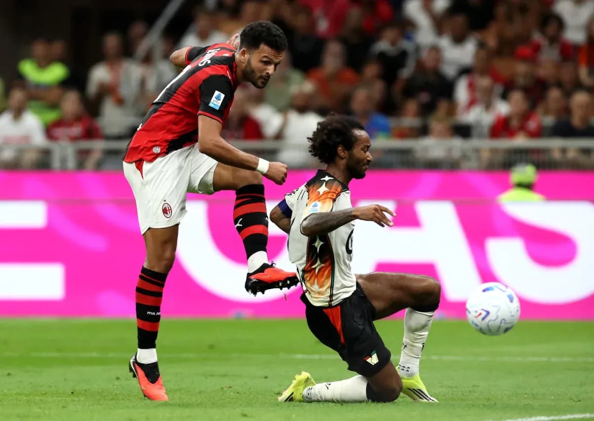 AC Milan player kicking ball against Venezia opponent AC Milan player kicking ball against Venezia opponent