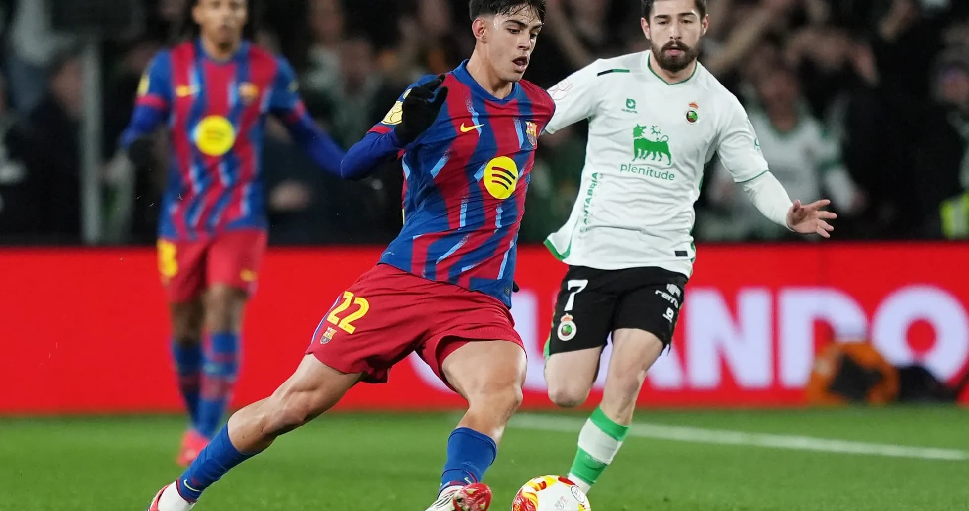 Barcelona player dribbling against Racing Santander Barcelona player dribbling against Racing Santander