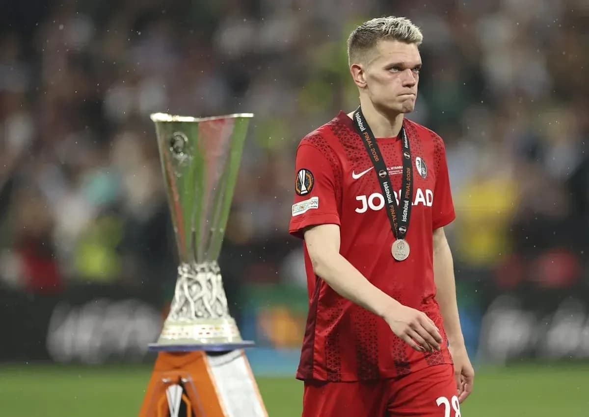Player in red jersey walking past UEFA trophy Player in red jersey walking past UEFA trophy