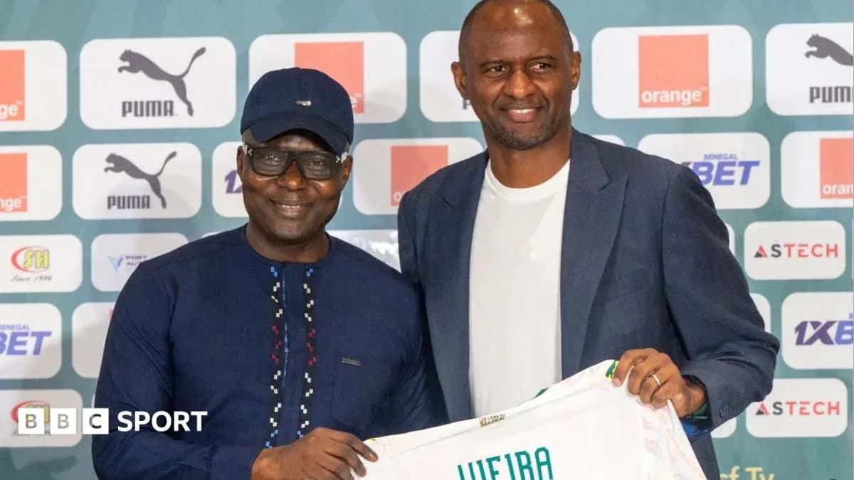 Two men holding a football shirt at press conference Two men holding a football shirt at press conference