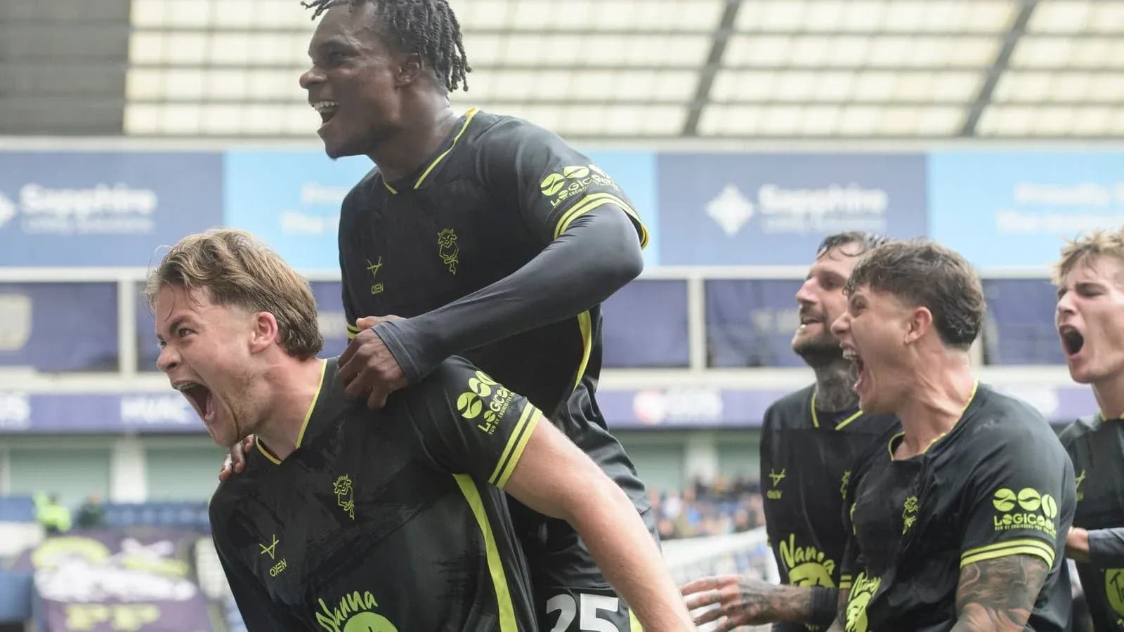 Players celebrating a goal on the pitch Players celebrating a goal on the pitch