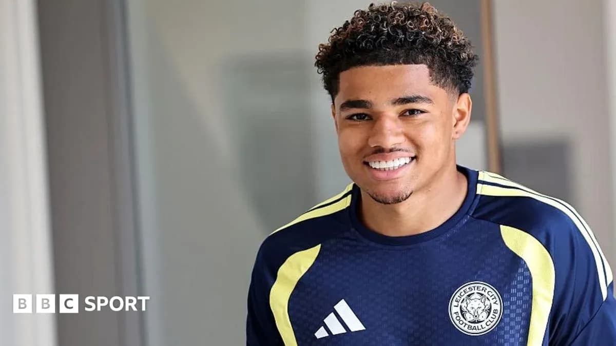 Football player smiling in Leicester City training kit Football player smiling in Leicester City training kit