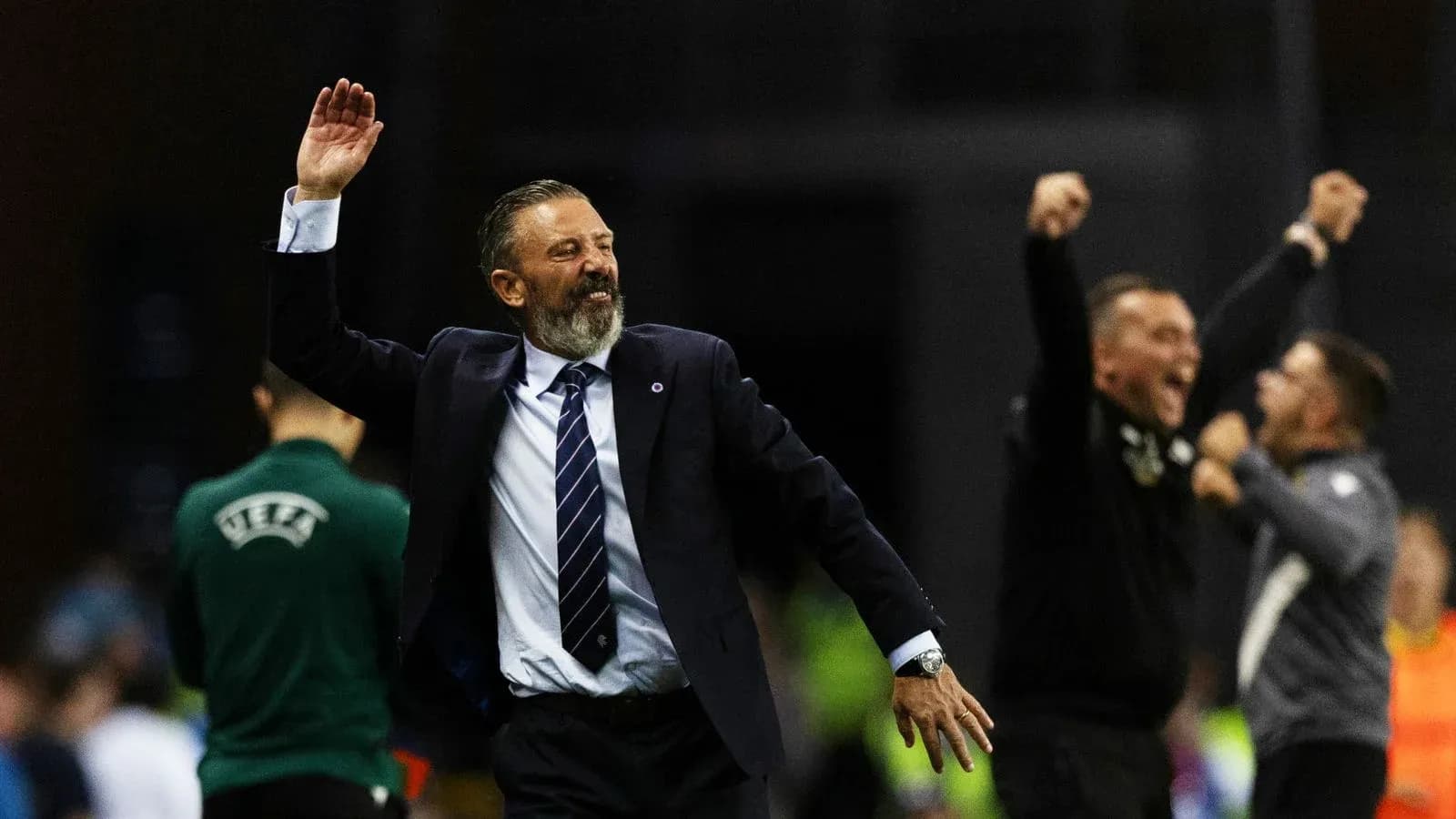 Coach celebrating victory with raised hand and smile Coach celebrating victory with raised hand and smile