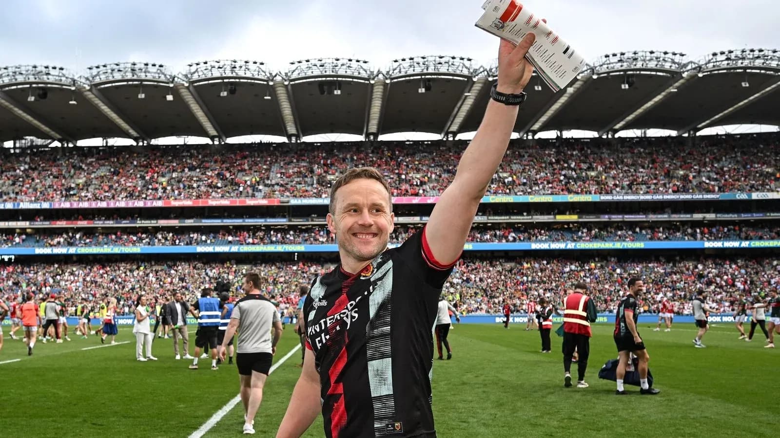 Player celebrating on field with fans in background Player celebrating on field with fans in background