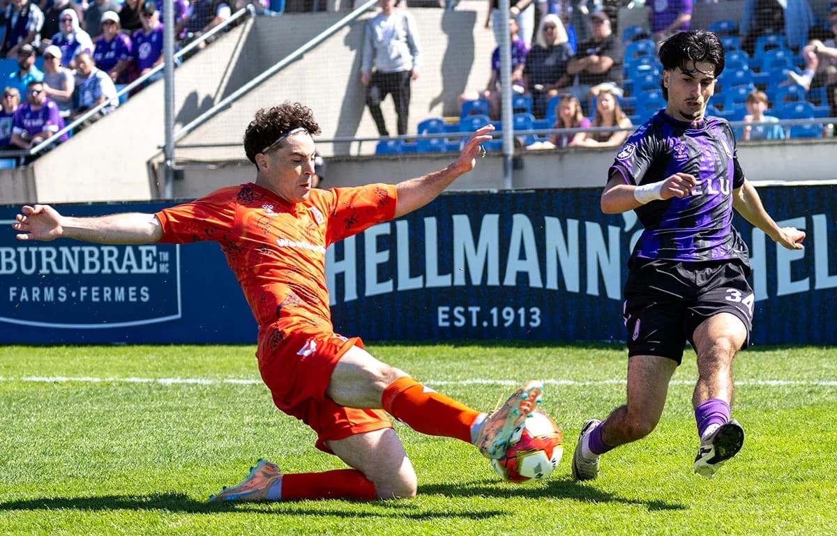 Player sliding to tackle ball during match Player sliding to tackle ball during match