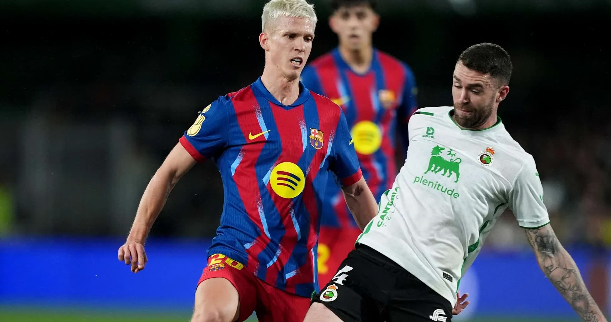 Barcelona player tackling Racing Santander opponent Barcelona player tackling Racing Santander opponent