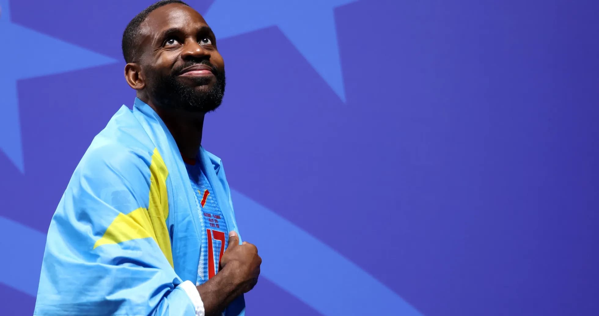 Athlete wearing a flag and looking upward Athlete wearing a flag and looking upward
