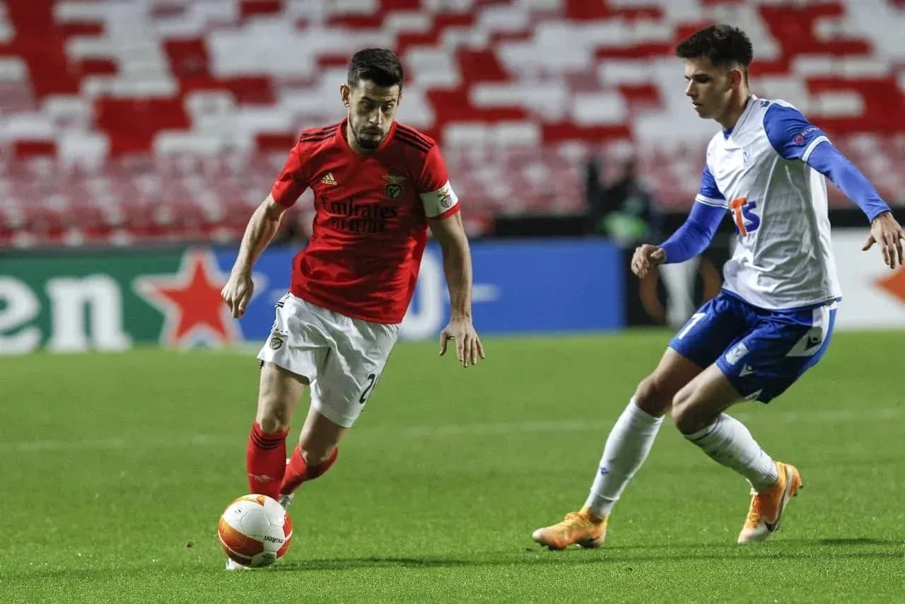 Benfica player dribbling against Lech Poznan opponent Benfica player dribbling against Lech Poznan opponent