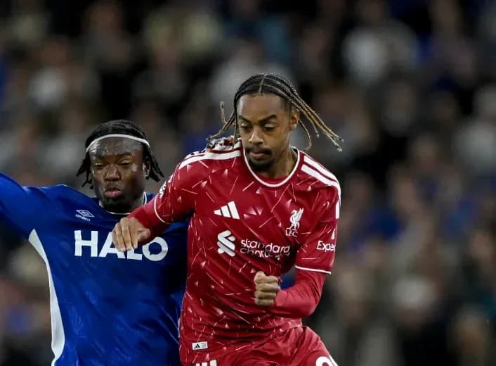 Liverpool player dribbling past opponent during match Liverpool player dribbling past opponent during match