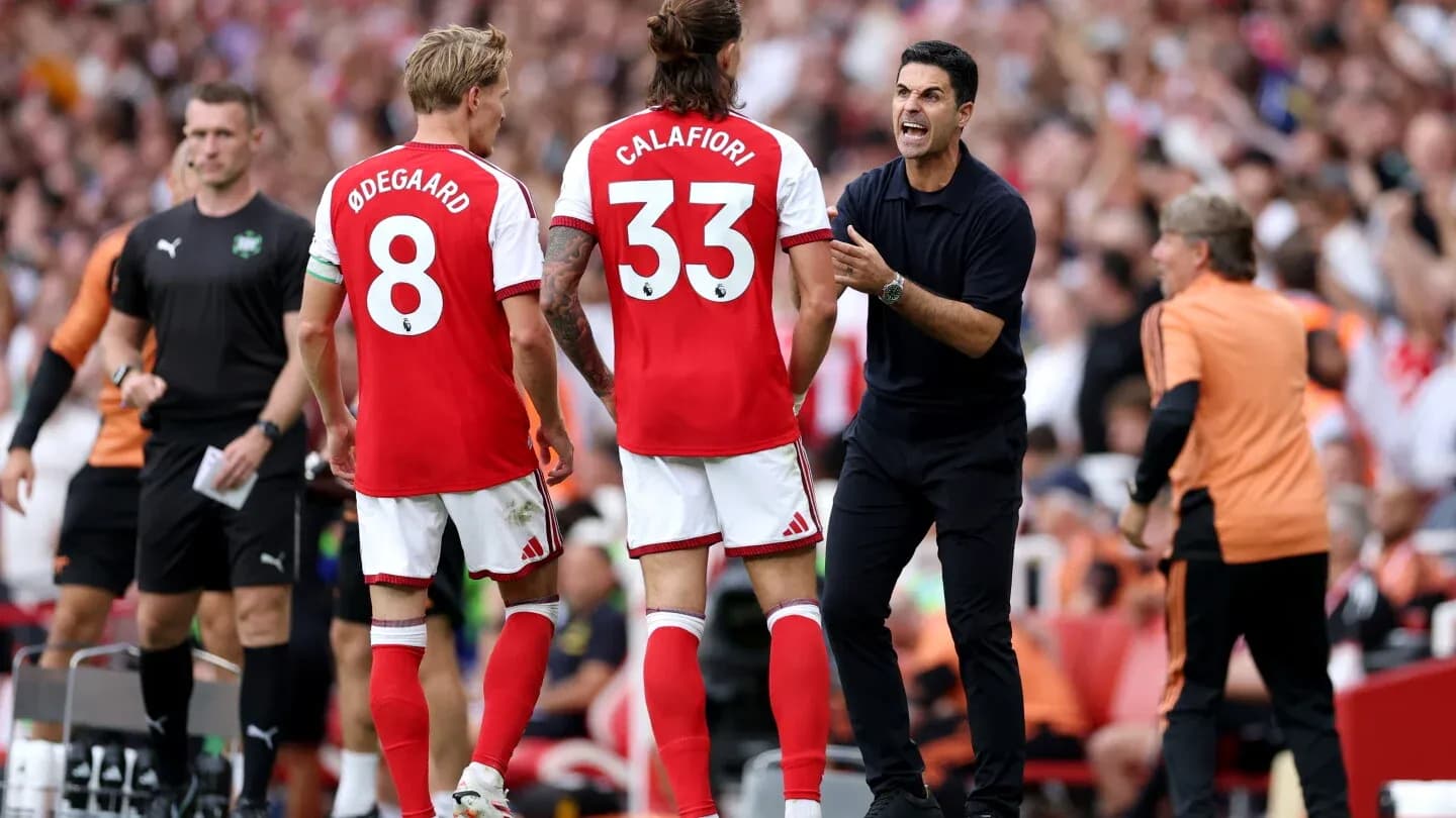 Arsenal players and manager discussing strategy during match Arsenal players and manager discussing strategy during match