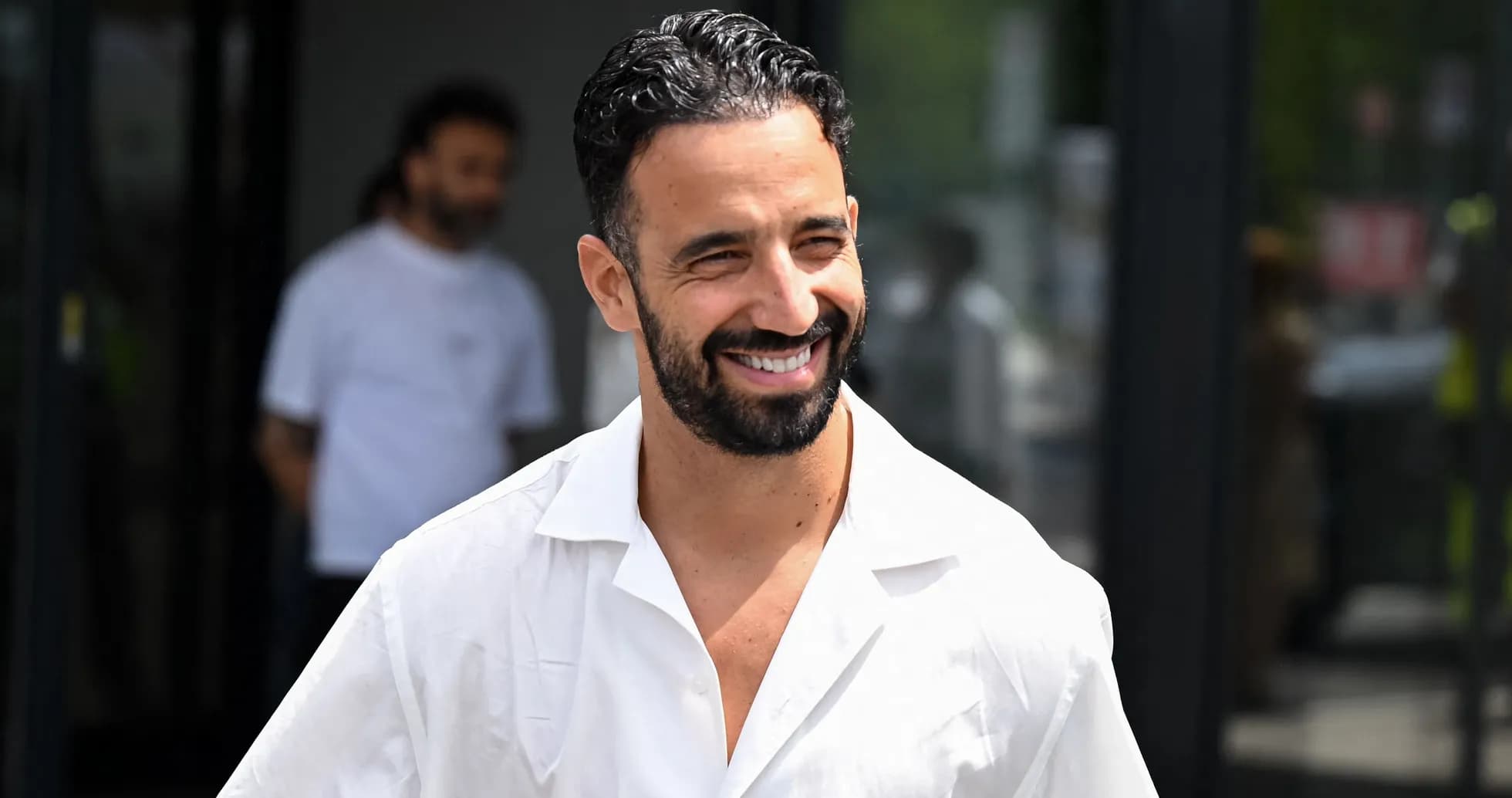 Smiling man in white shirt walking outside building Smiling man in white shirt walking outside building