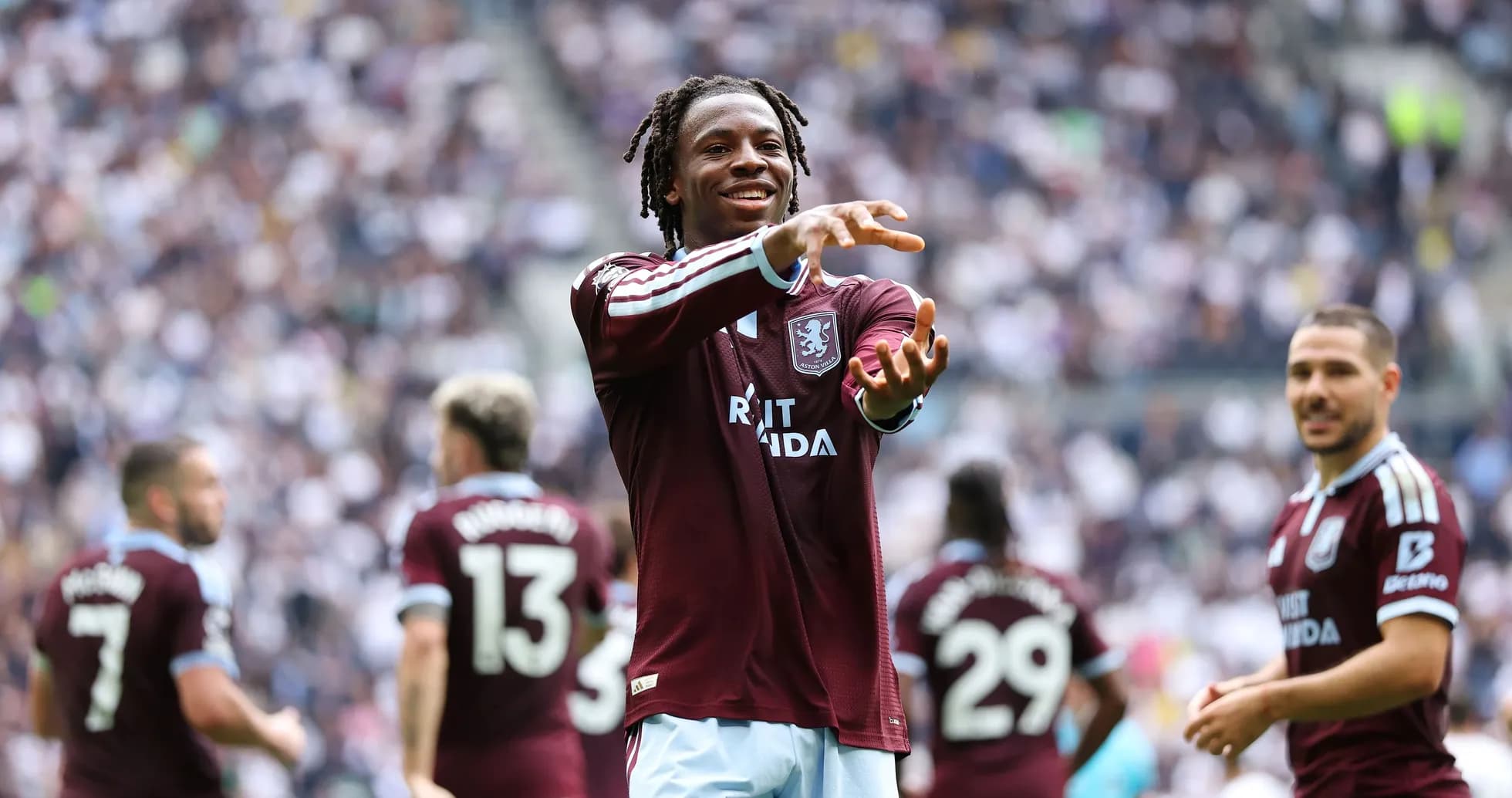 Aston Villa player celebrating with teammates on field Aston Villa player celebrating with teammates on field