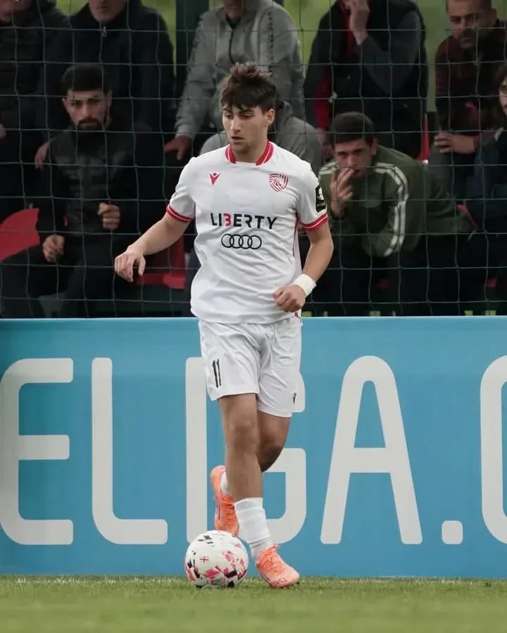 Player in white kit dribbling a soccer ball Player in white kit dribbling a soccer ball