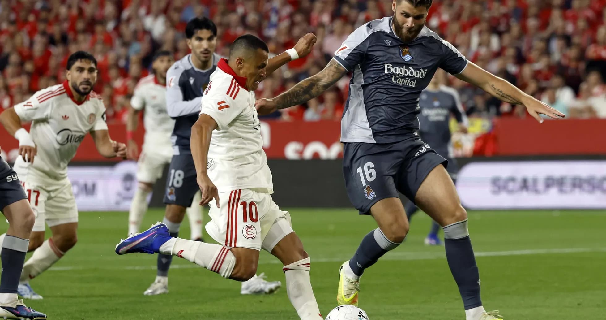 Sevilla player challenging Real Sociedad opponent Sevilla player challenging Real Sociedad opponent