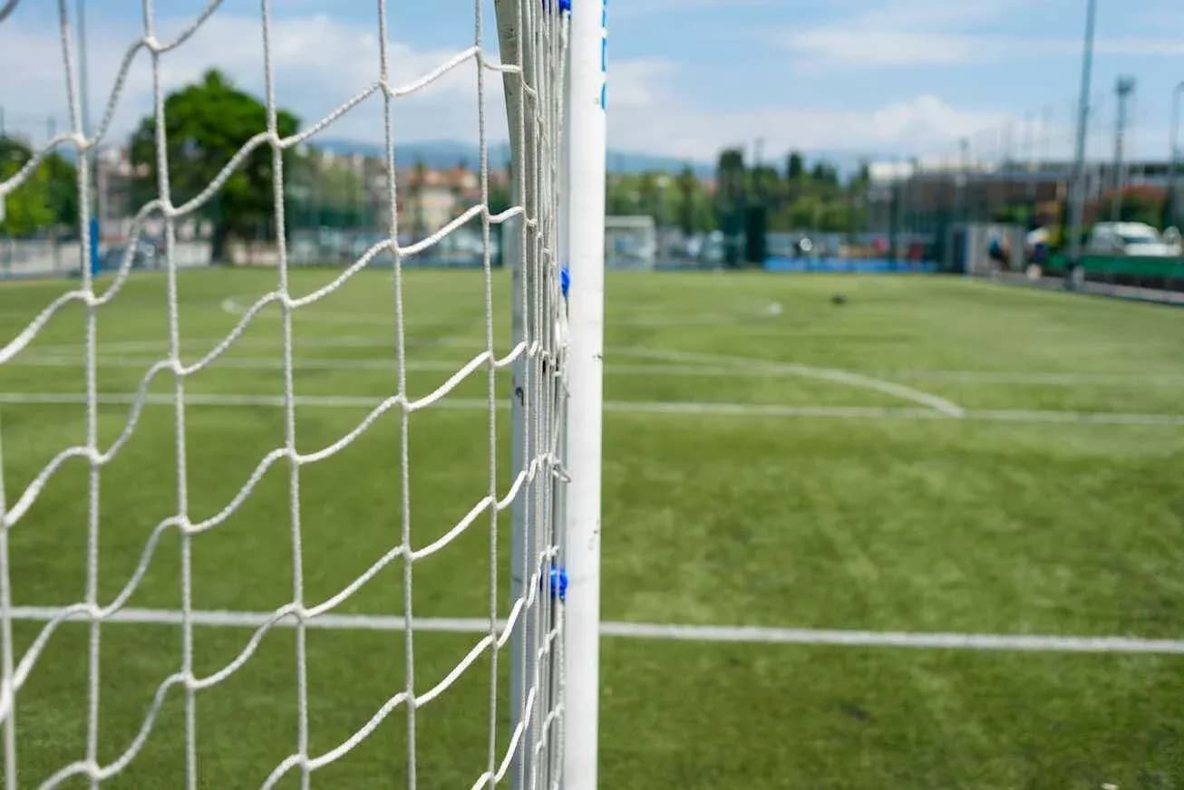 View of a soccer goal on a grassy field View of a soccer goal on a grassy field