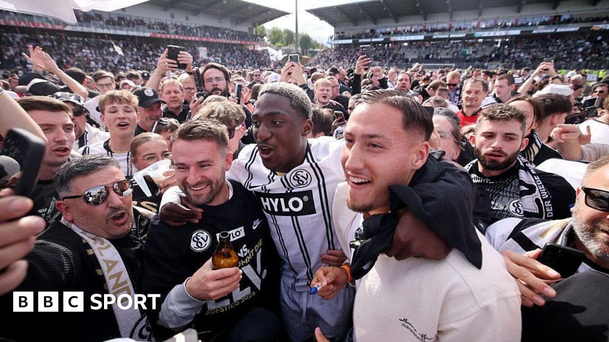 Fans celebrating with players on the pitch Fans celebrating with players on the pitch