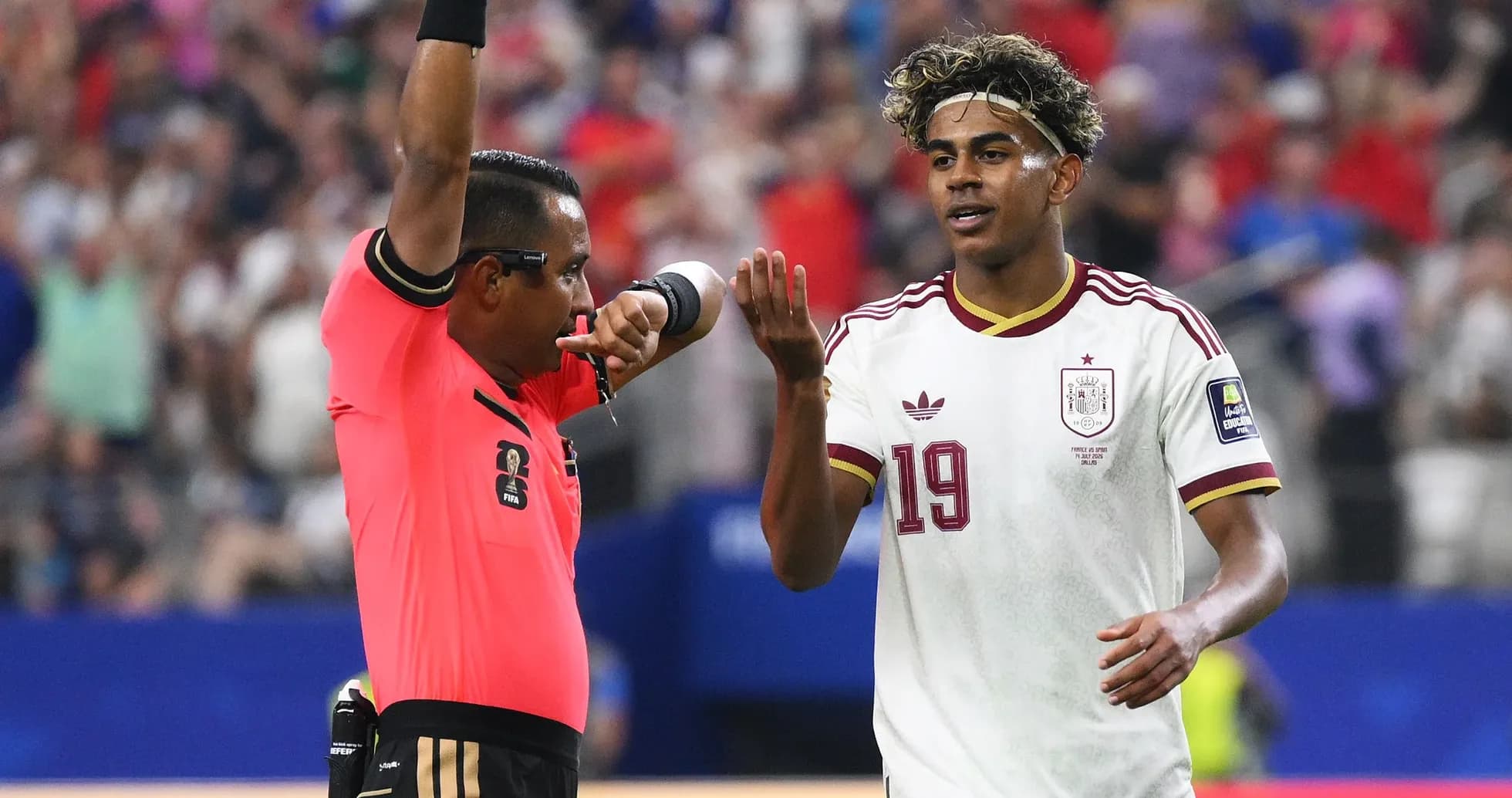 Referee signaling while player looks on during match Referee signaling while player looks on during match