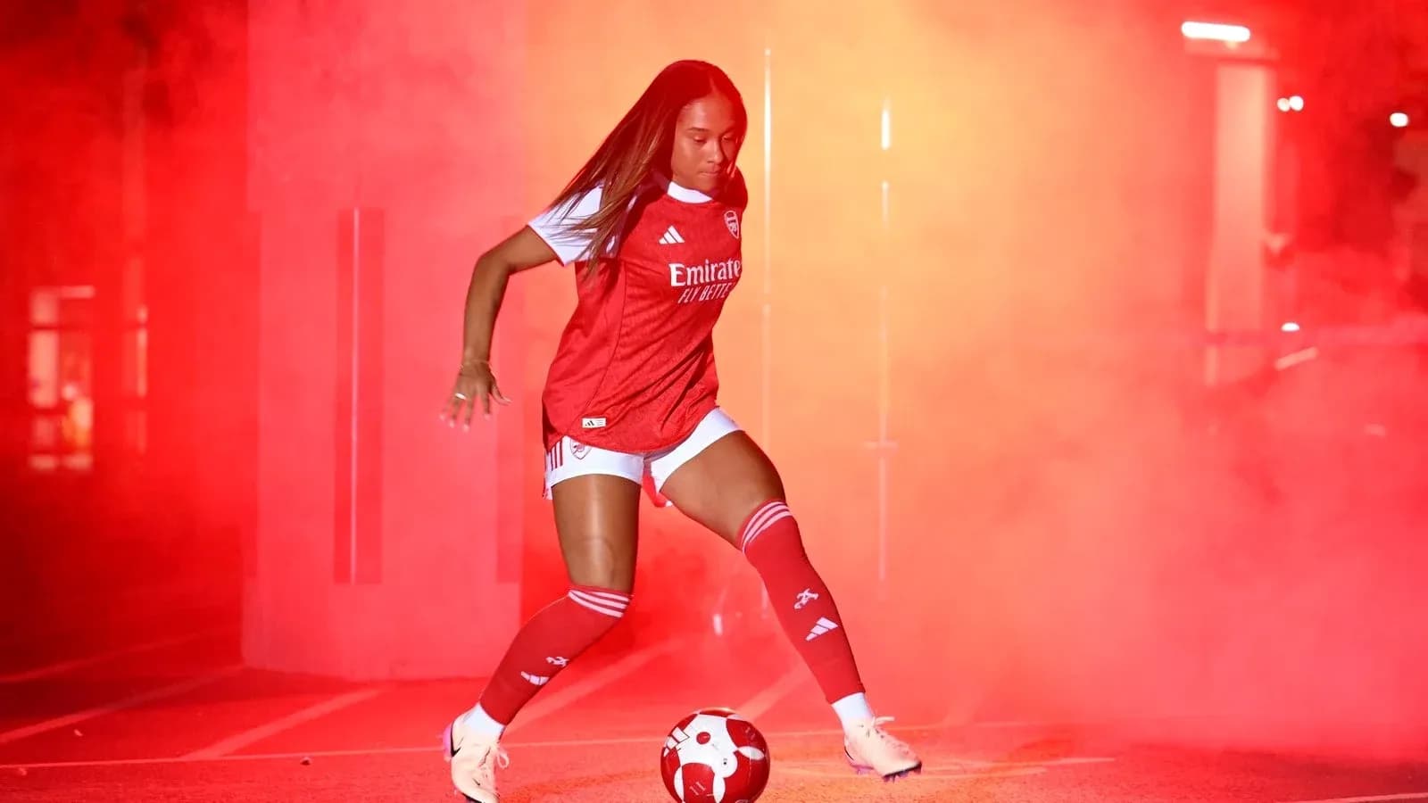 Player in Arsenal kit with soccer ball in smoke Player in Arsenal kit with soccer ball in smoke