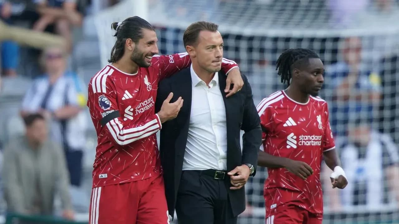 Liverpool players celebrating with their manager on field Liverpool players celebrating with their manager on field
