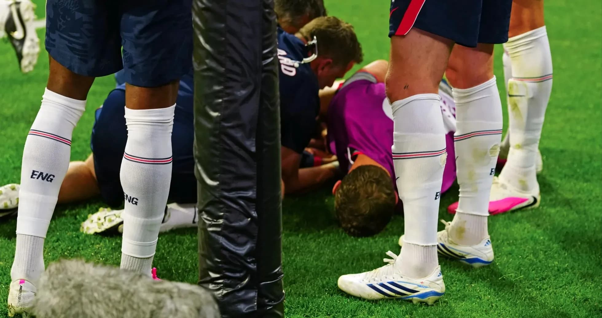 Players attending to an injured teammate on field Players attending to an injured teammate on field