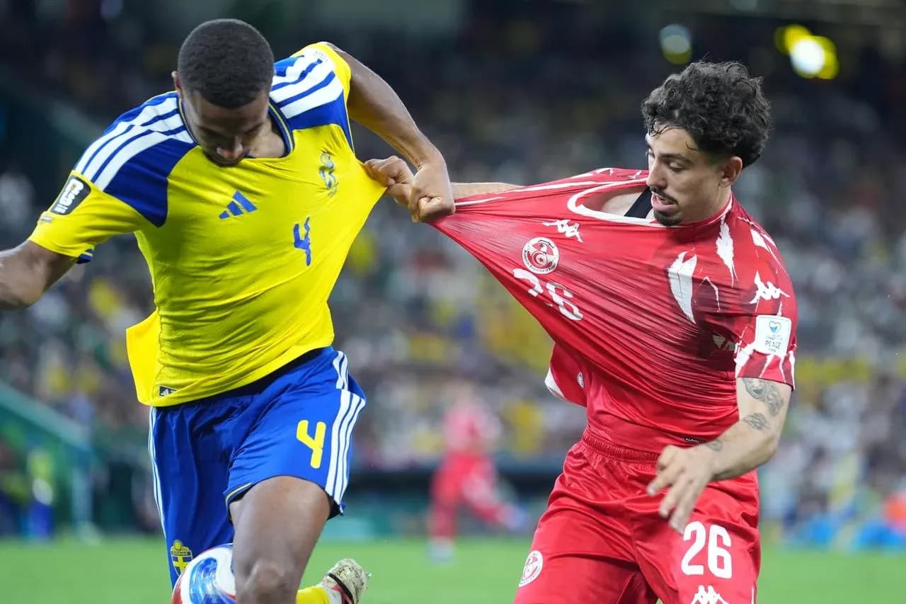 Sweden player challenges Tunisia player during match Sweden player challenges Tunisia player during match