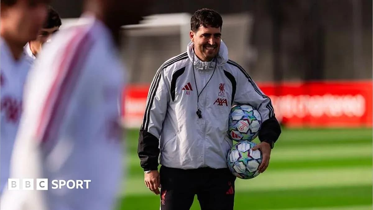 Coach carrying footballs during training session Coach carrying footballs during training session