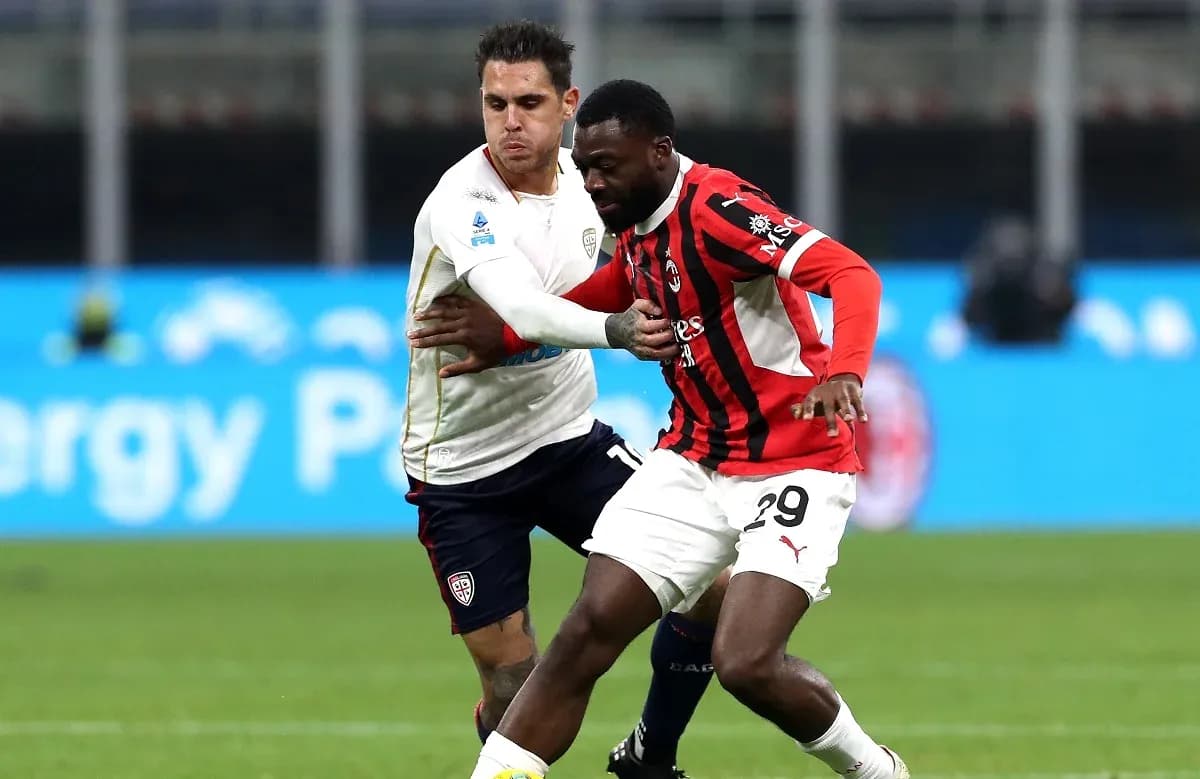 AC Milan player challenging Cagliari opponent AC Milan player challenging Cagliari opponent